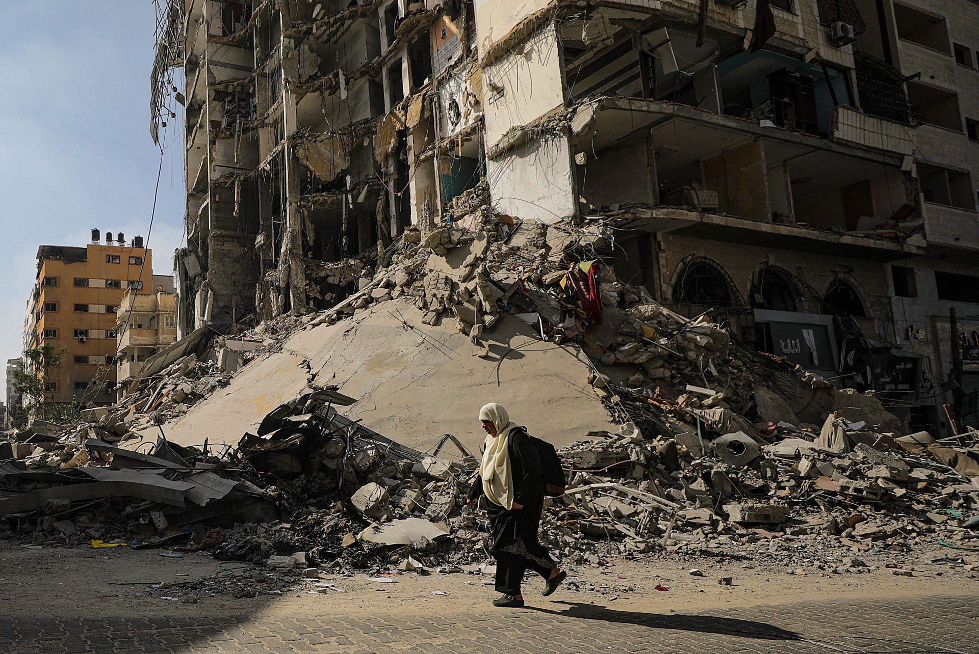 Uen femme marche dans Gaza City en ruine